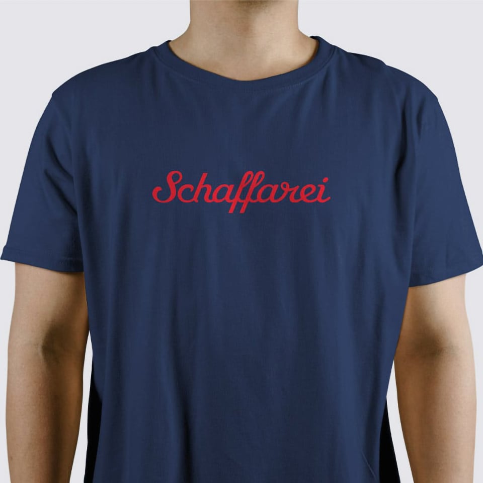 Blaues T-Shirt mit rotem Brustaufdruck Schaffarei.