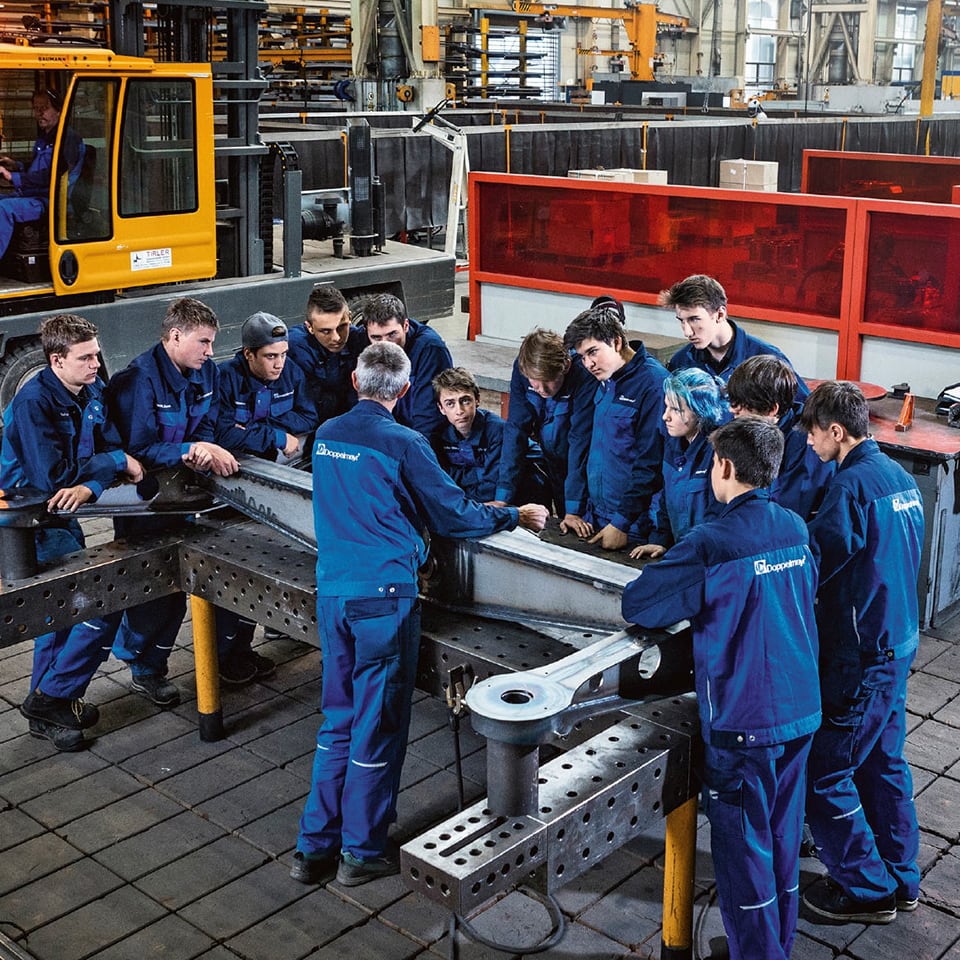 Gruppenbild der Lehrlinge in einer Besprechung mit dem Ausbildner